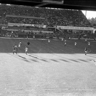 Black-and-white soccer match with players on field.