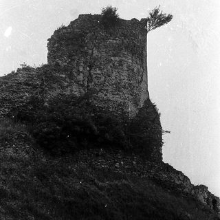 Ruined stone tower on rocky cliff.