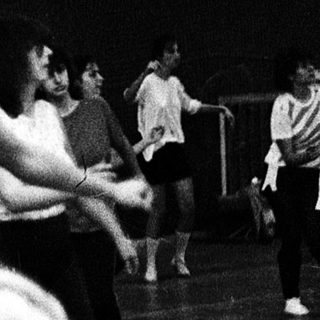 Women practicing gymnastics or dance indoors.