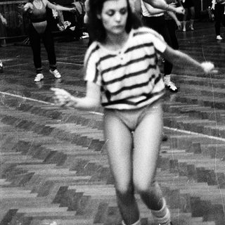 Women practicing gymnastics or dance indoors.