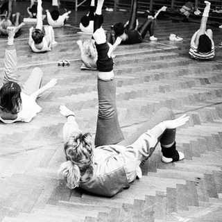 Group aerobics class in gym setting.