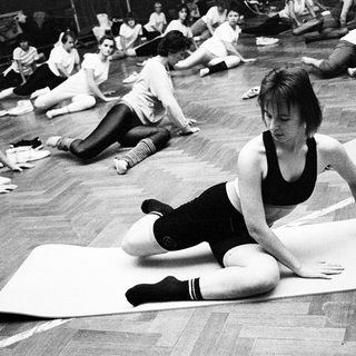 Group yoga or stretching class in gym setting.