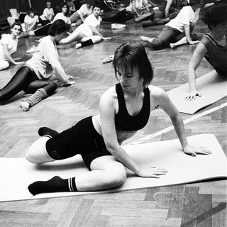 Group yoga or stretching class in gym setting.