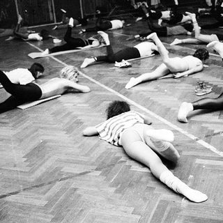 Group fitness class performing floor exercises.