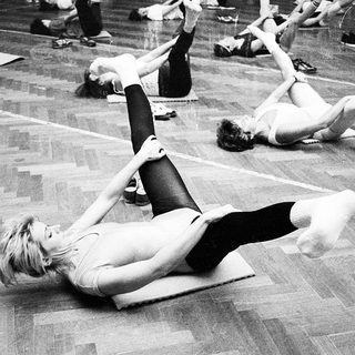 Group fitness class performing floor exercises.