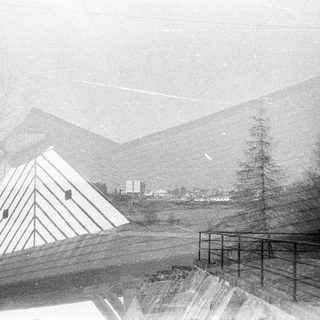 Mountain landscape with pyramid-shaped tent and fog.