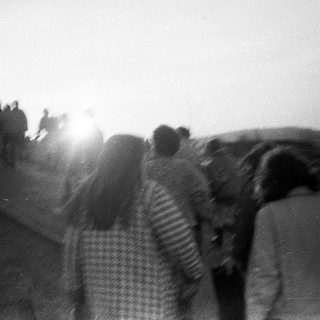 People walking outdoors during sunset or sunrise.