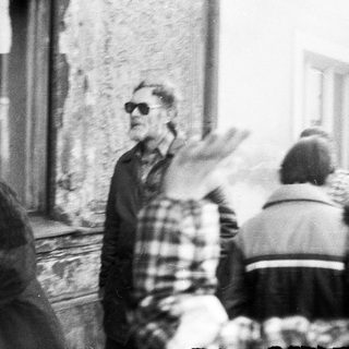People gathered outdoors in a lively, possibly celebratory street scene.