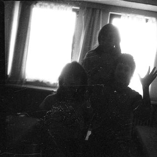 Two people sitting indoors near a window.