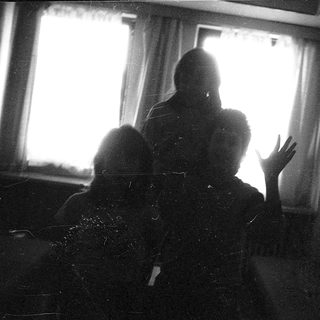 Two people sitting indoors near a window.