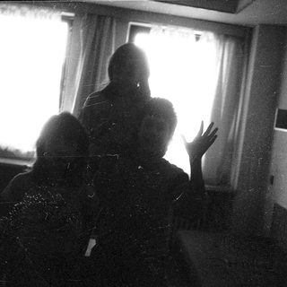 Two people sitting indoors near a window.