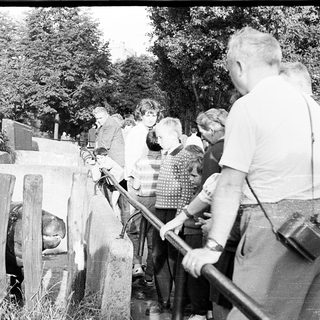 People observing a historic outdoor memorial site.
