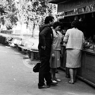 Street market stall with people purchasing items.