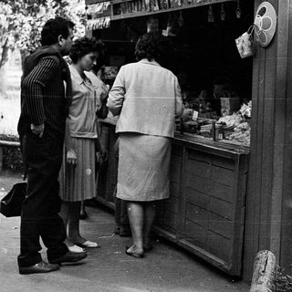 Street market stall with people purchasing items.