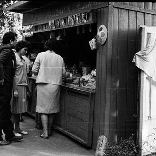 Street market stall with people purchasing items.