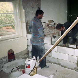 Renovation workers repairing damaged interior walls.