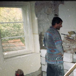 Renovation workers repairing damaged interior walls.