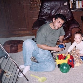 Man and young child playing with toys indoors.