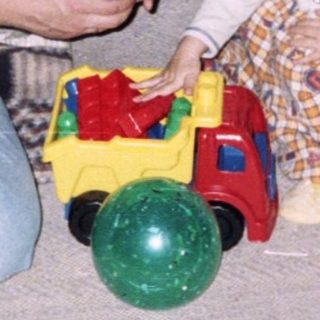 Man and young child playing with toys indoors.