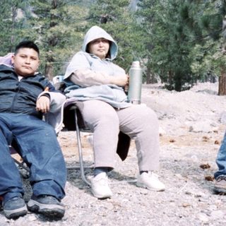 People camping outdoors in mountainous area.