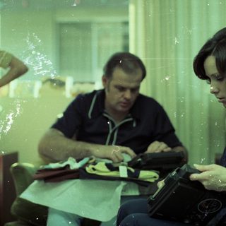 Family eating together indoors with food trays.
