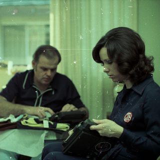 Family eating together indoors with food trays.