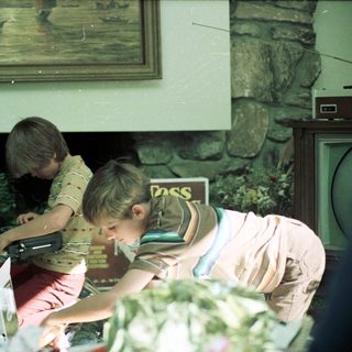 Two boys playing video game indoors.