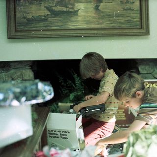 Two boys playing video game indoors.