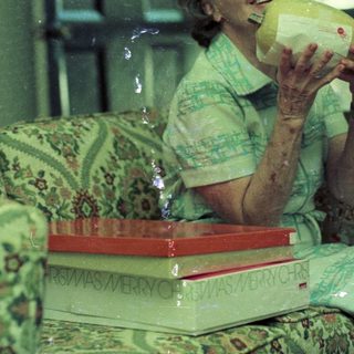 Woman drinking from a pineapple indoors.