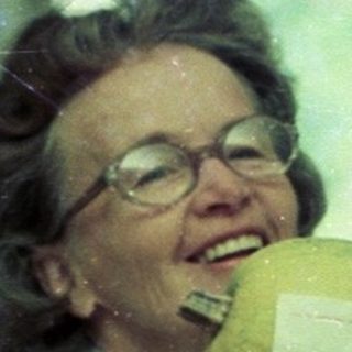 Woman drinking from a pineapple indoors.