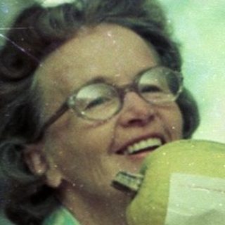 Woman drinking from a pineapple indoors.
