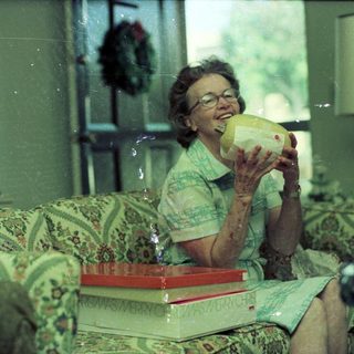 Woman drinking from a pineapple indoors.