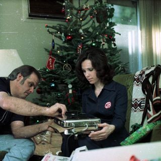Family decorating and opening holiday gifts indoors.