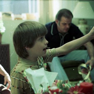 Two boys and a man at a birthday celebration.