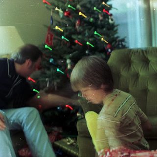 Family decorating Christmas tree with lights.