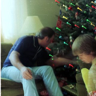 Family decorating Christmas tree with lights.