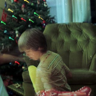 Family decorating Christmas tree with lights.