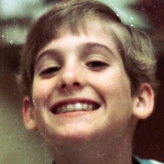 Happy young boy smiling indoors.