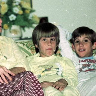 Family portrait indoors with elderly woman and two children.