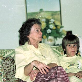 Family portrait indoors with elderly woman and two children.