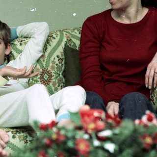 Family enjoying indoor gathering in cozy living room.