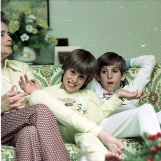 Family enjoying indoor gathering in cozy living room.