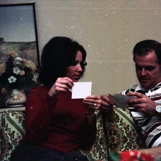 Two people playing card game indoors.