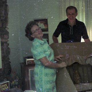Family decorating Christmas tree indoors.