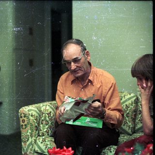 Three people sitting indoors, reading and relaxing.