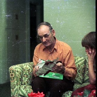 Three people sitting indoors, reading and relaxing.