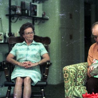 Three people sitting indoors, reading and relaxing.