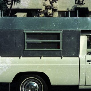 Vintage white delivery van with dark roof.