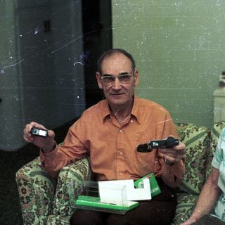 Two elderly people playing video game together indoors.