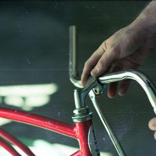 Person adjusting bicycle handlebar stem.